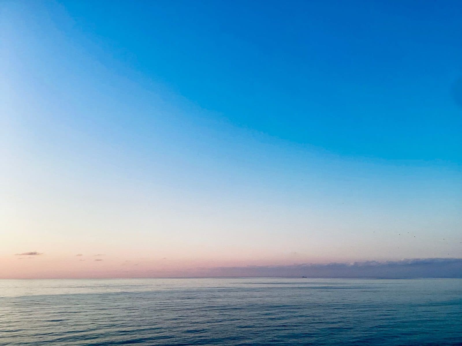 First light breaking over a calm horizon at dawn