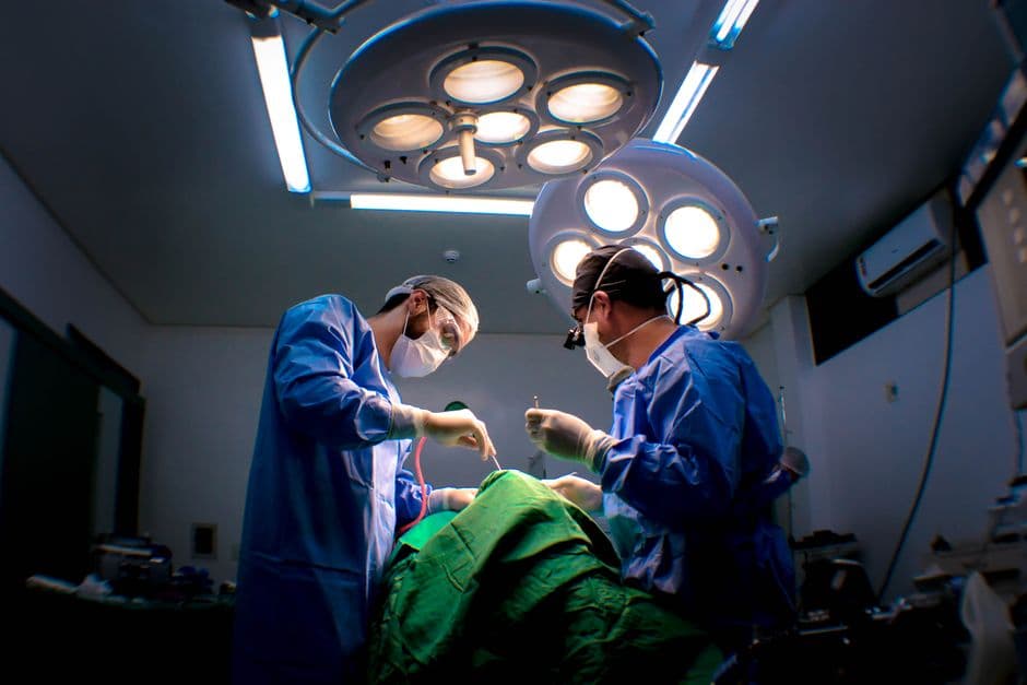 Two surgeons performing surgery in a well-equipped operating room.